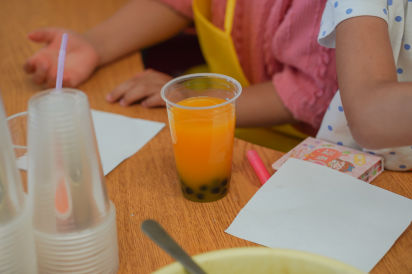 A cup of mango bubble tea on a desk in a YMCA child care classroom.