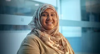 A close-up of a smiling immigrant services client.