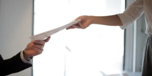 a person handing documents over to someone else