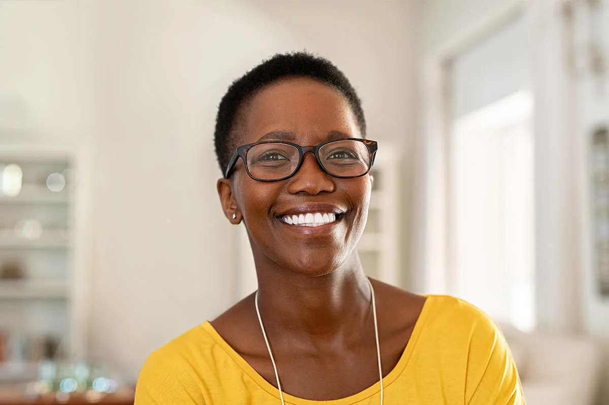 a black woman with glasses smiling