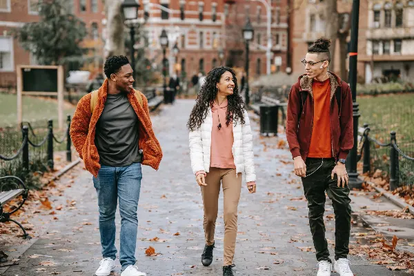 three youth walking on a campus