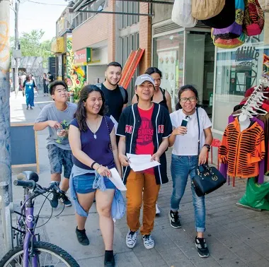 six youth walk down the sidewalk