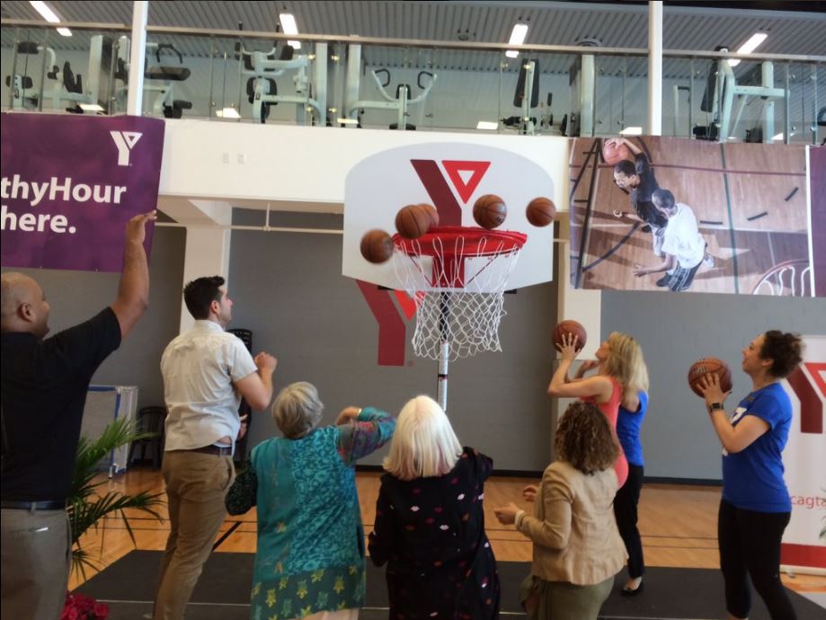 Special speakers toss their basketballs into the special YMCA net in the Cooper Koo YMCA gym