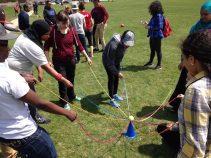 Students work together to complete a team building initiative