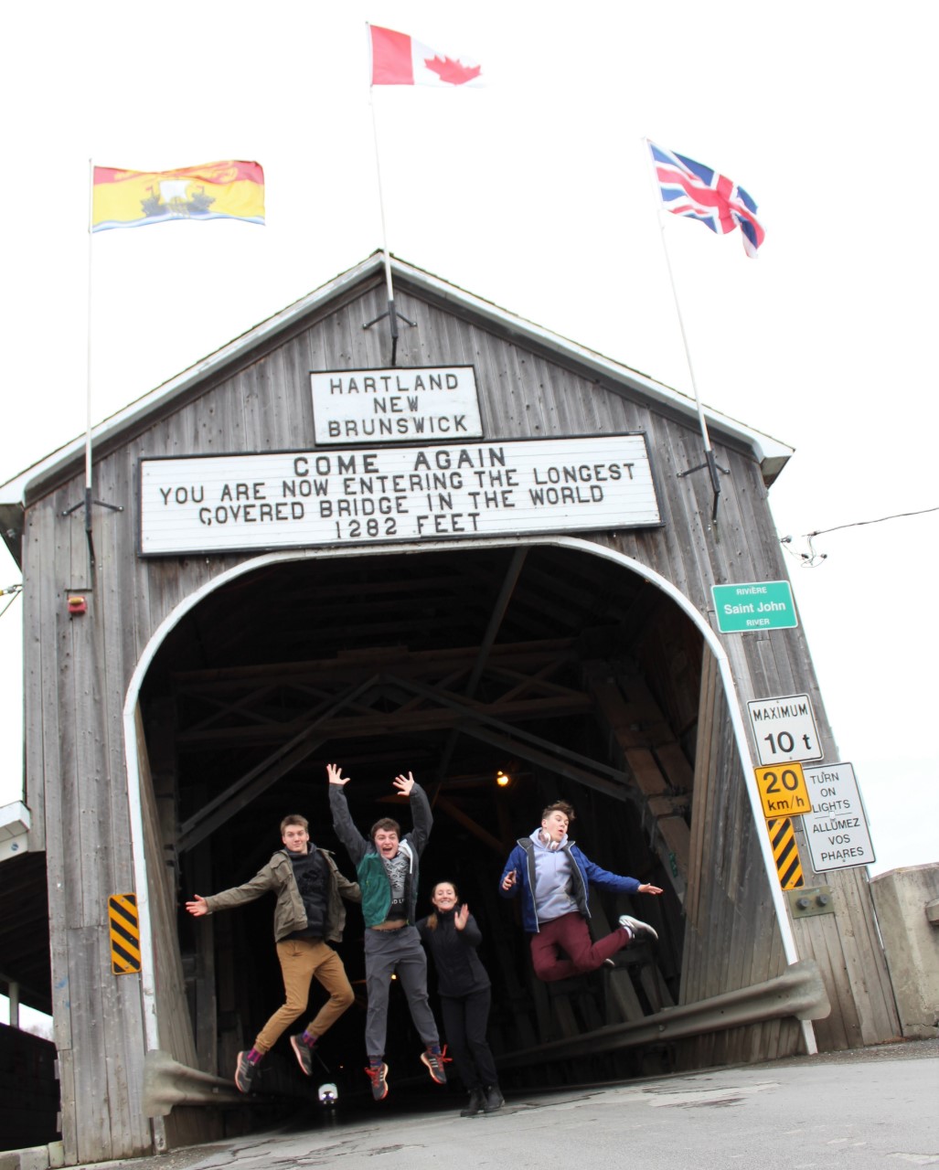 Four youth jumping in front of a building