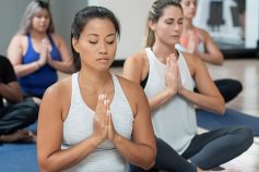 Group of people sitting in a yoga class and meditating
